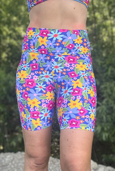 Colourful floral shorts worn by a person with a blurred natural background