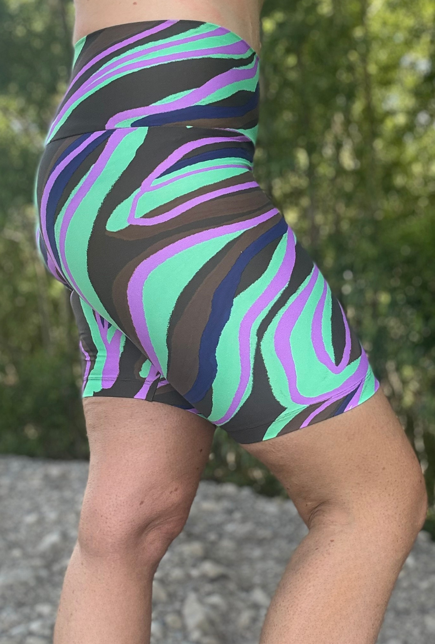 Colourful zebra-striped shorts worn by a person outdoors with greenery in the background